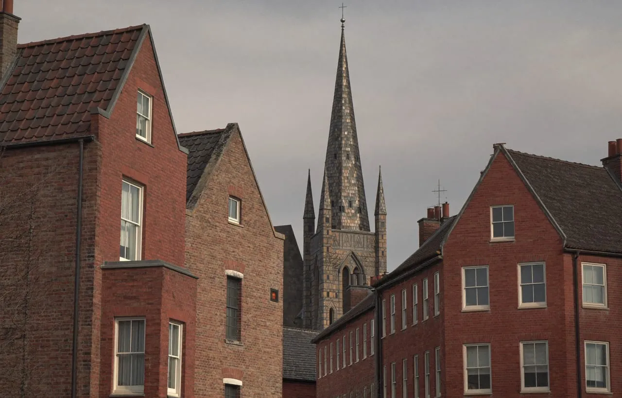 Rue de maisons en brique de Tourcoing et flèche néogothique